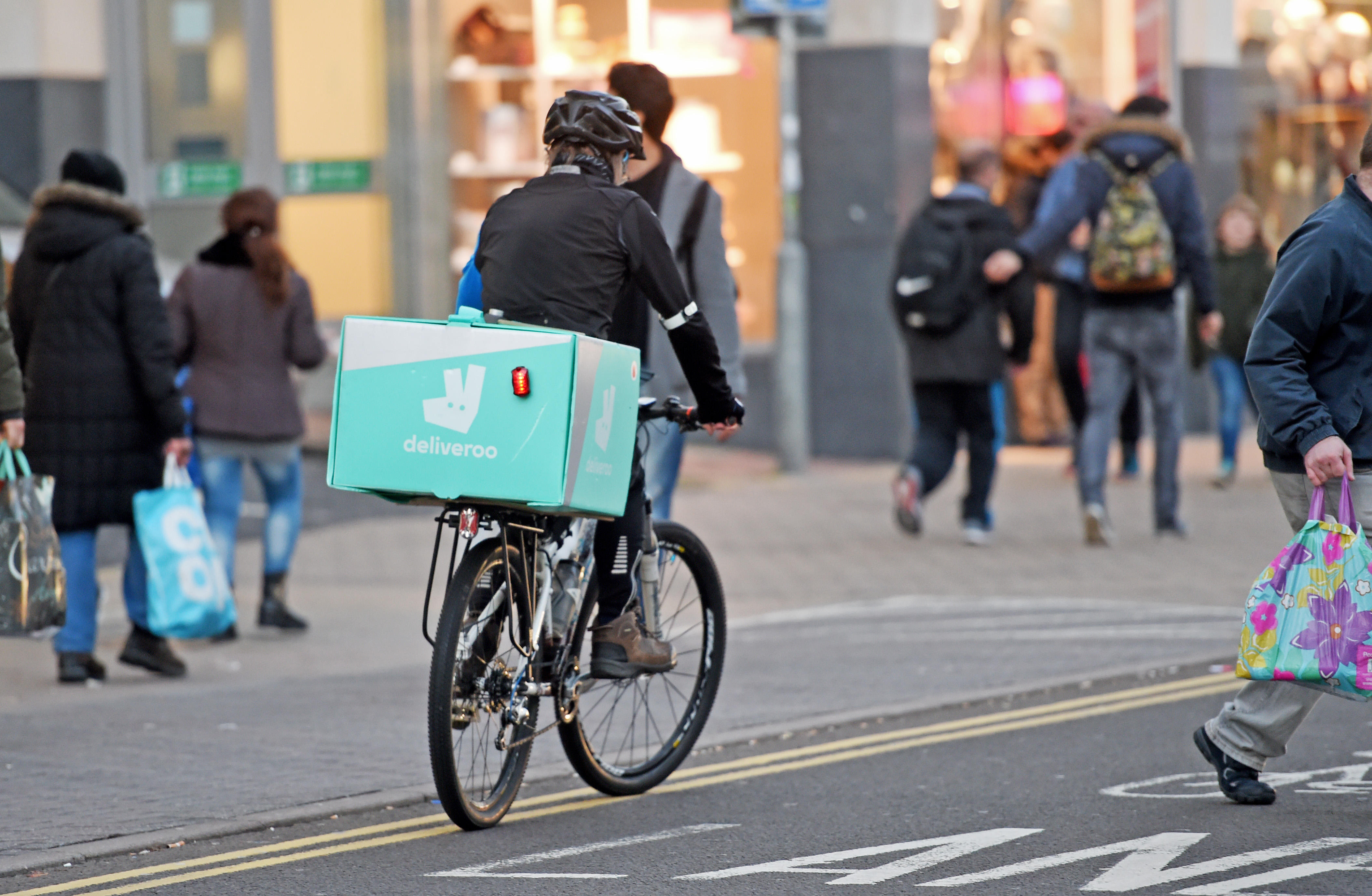 Deliveroo cyclist delivering food by bicycle.