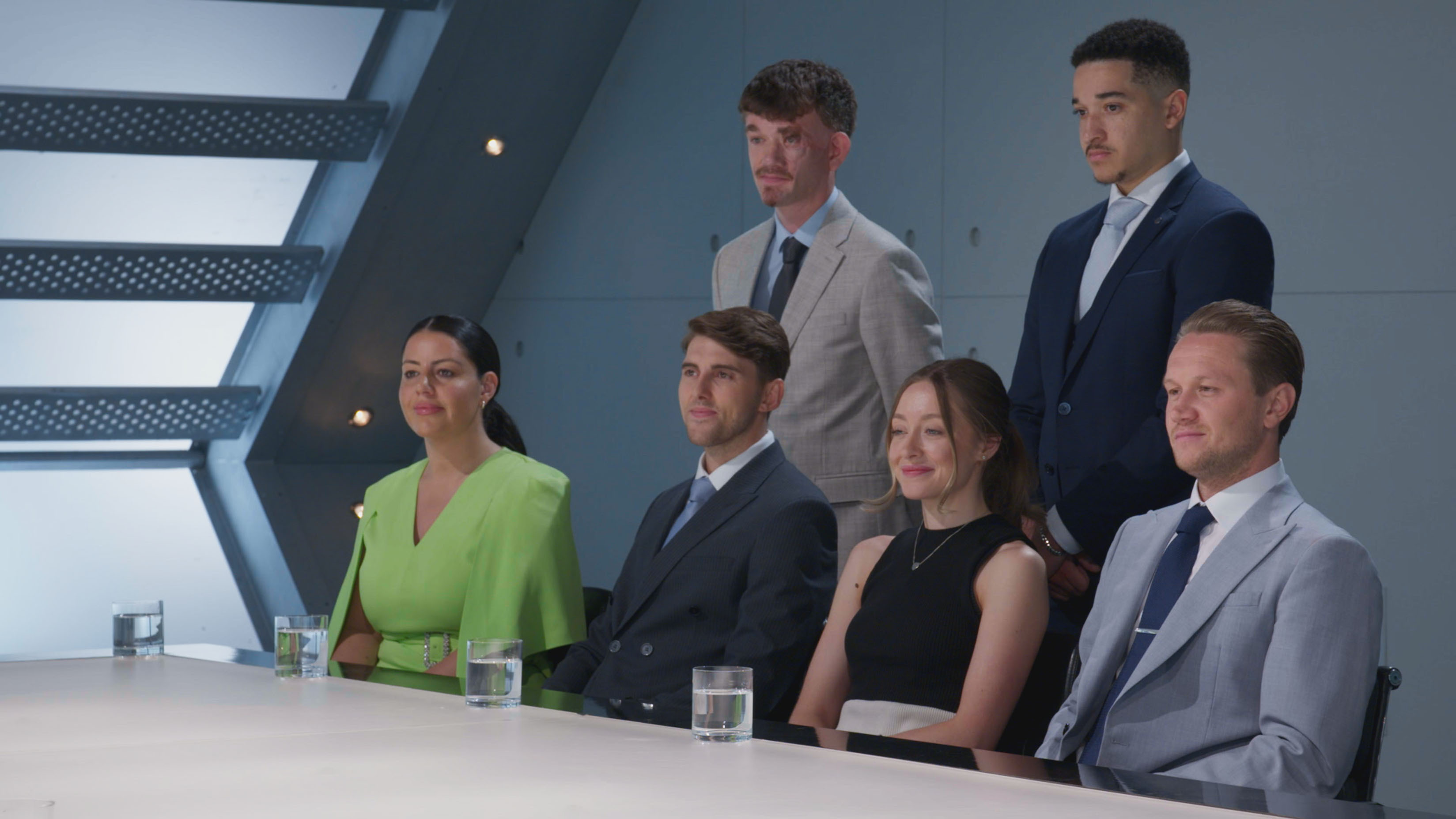 The Apprentice Season 19 candidates at a boardroom table.
