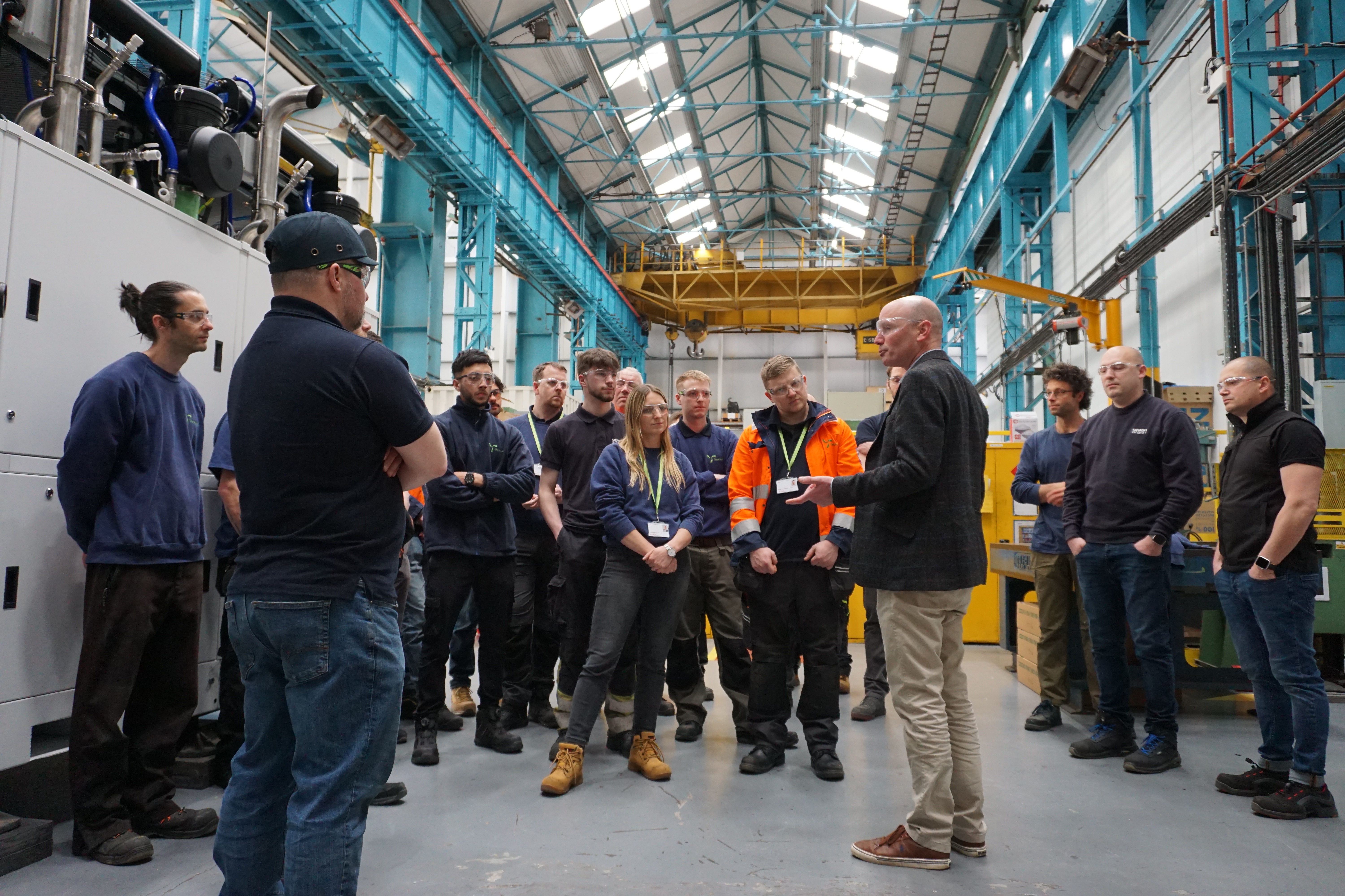 Andrew Cunningham, founder and CEO of GeoPura, interacting with colleagues in a factory environment.
