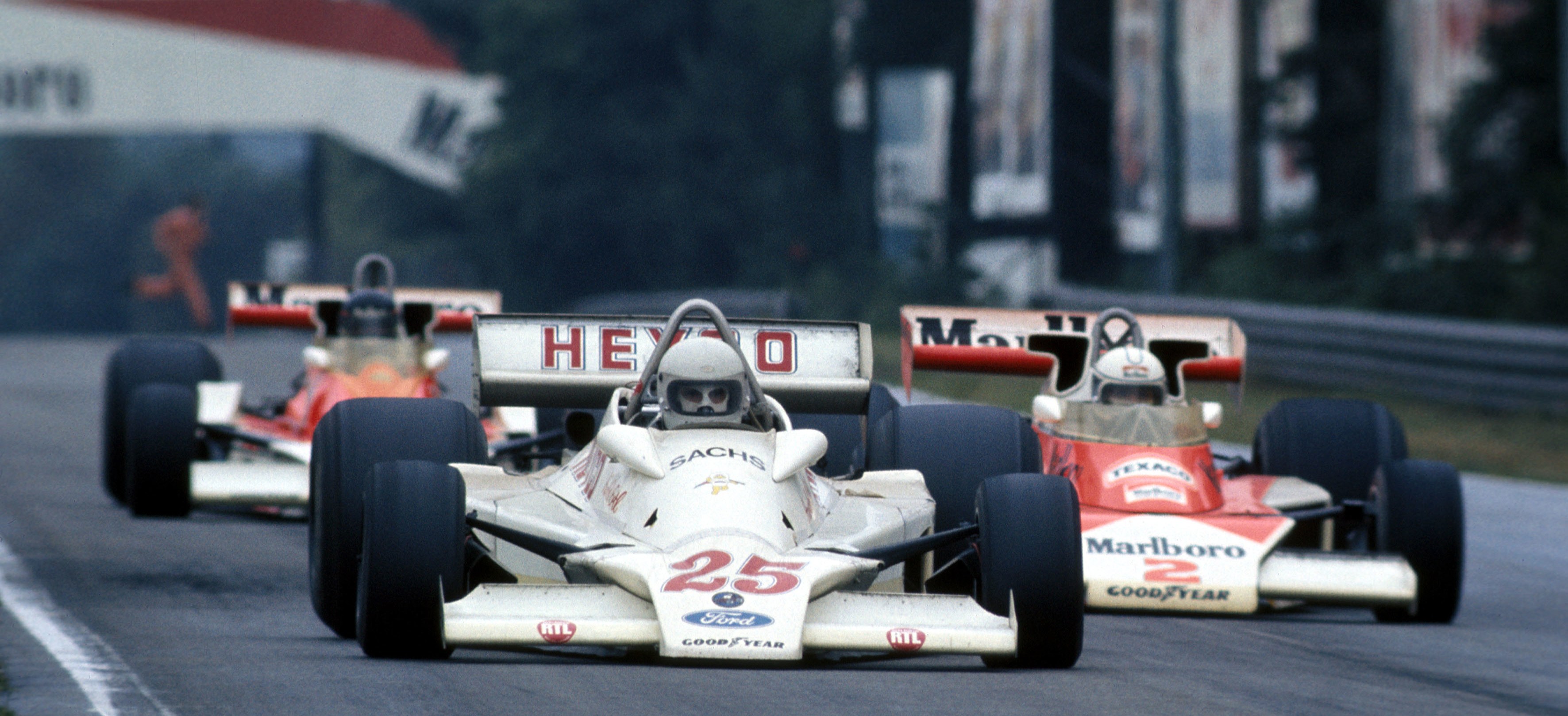 Three Formula 1 race cars racing on a track.